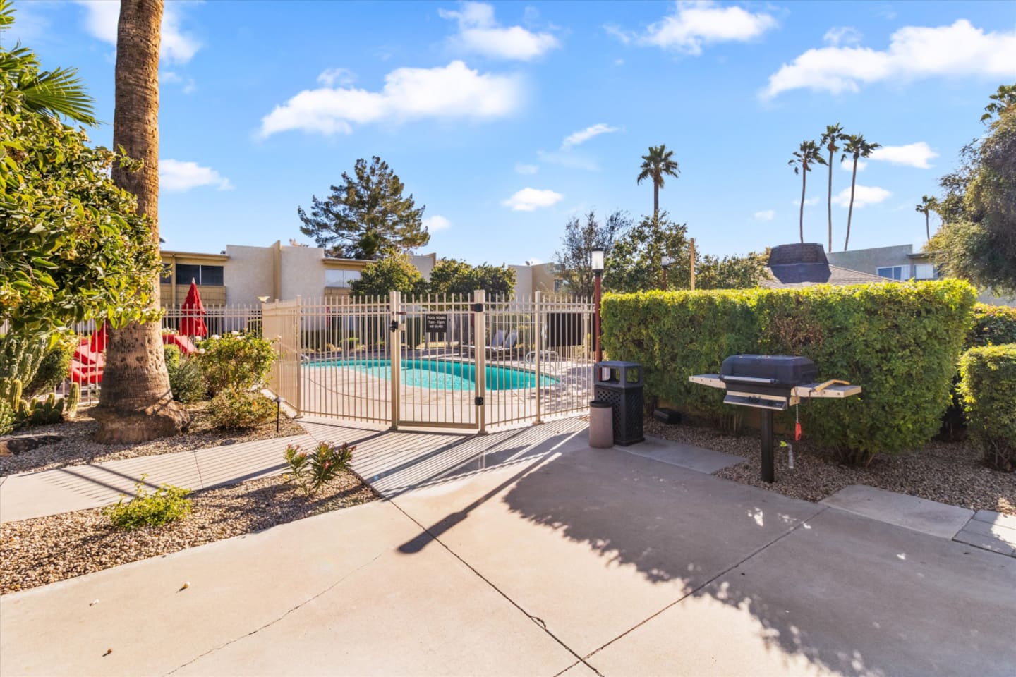 Shared pool area with BBQ grill, lounge seating nearby, and a simple spot to enjoy time outside.
