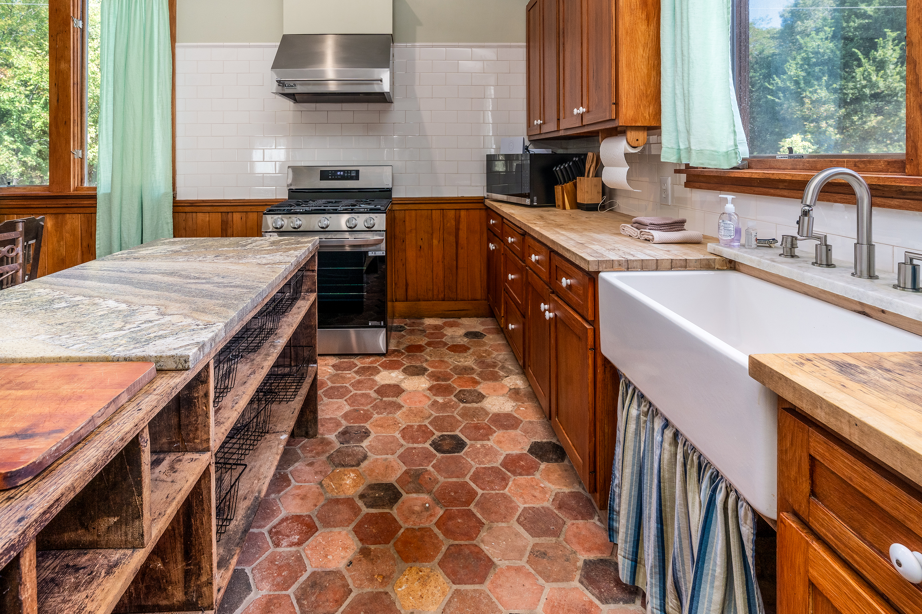 Spacious kitchen with farmhouse sink and butcher block countertops for meal prep.