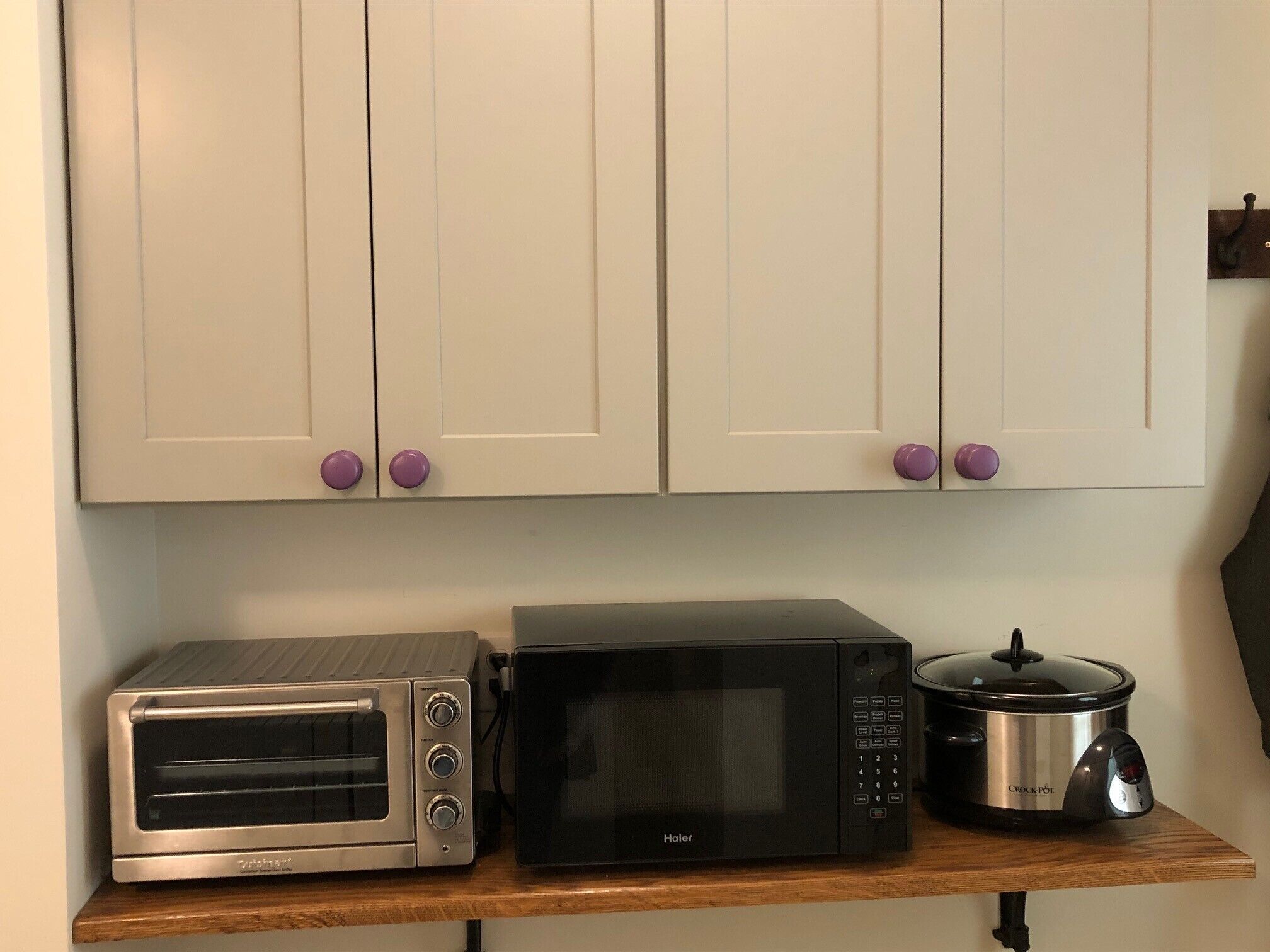 Toaster oven, microwave, and crock pot located in the laundry area. 