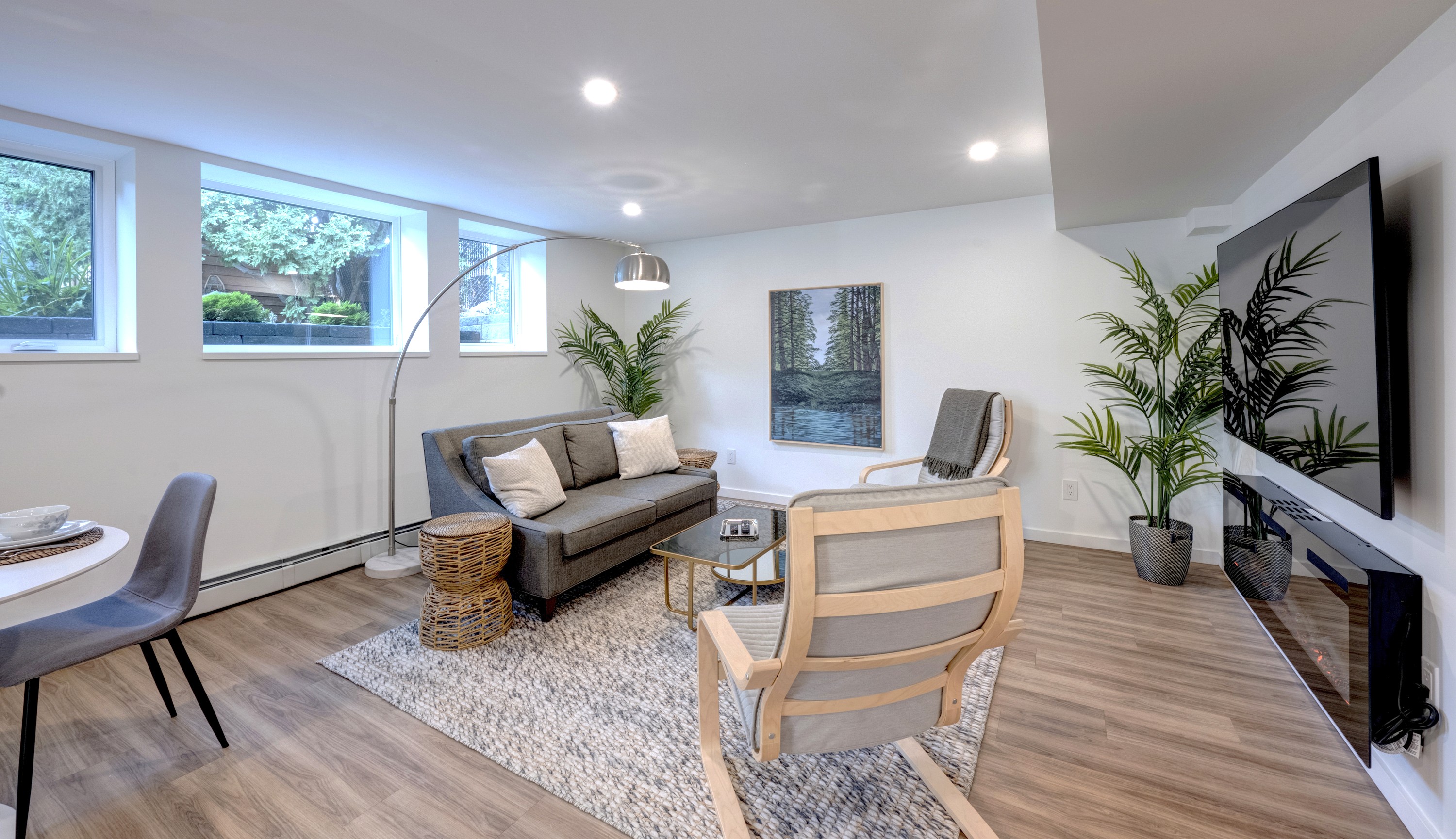 Bright living room with large windows and a calm, uncluttered layout.