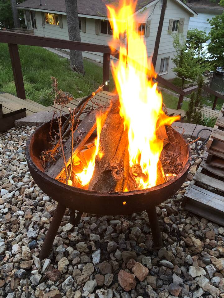 Outdoor wood firepit next to the hot tub with the deck providing natural seating areas. 