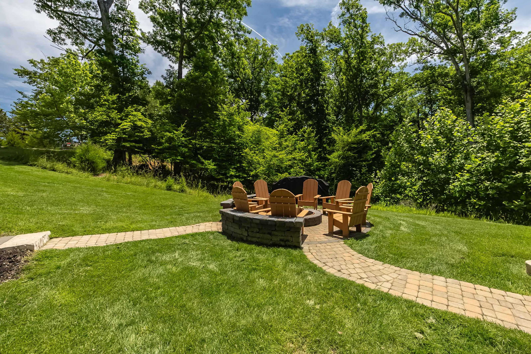 Relax around the fire pit beneath the trees.