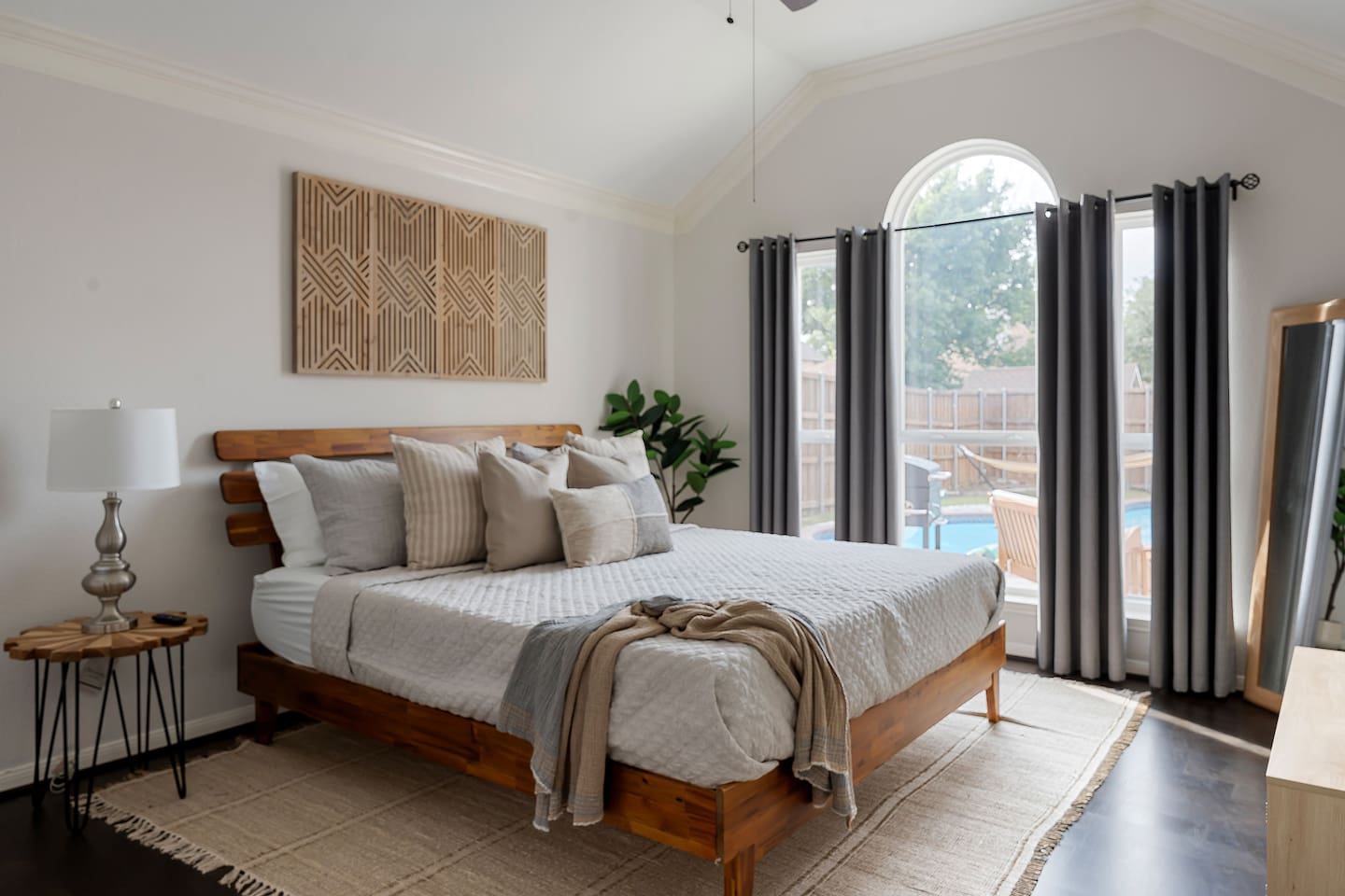Embracing luxury and comfort in this spacious bedroom, where a king-size bed beckons amidst plush cushions. While glass window reveals a breathtaking view of the backyard pool area, creating a perfect blend of comfort and serenity.
