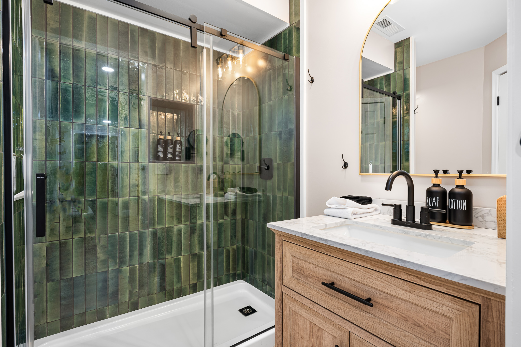 A modern bath with rich green tile and spa-style amenities—perfect for unwinding after a mountain adventure.