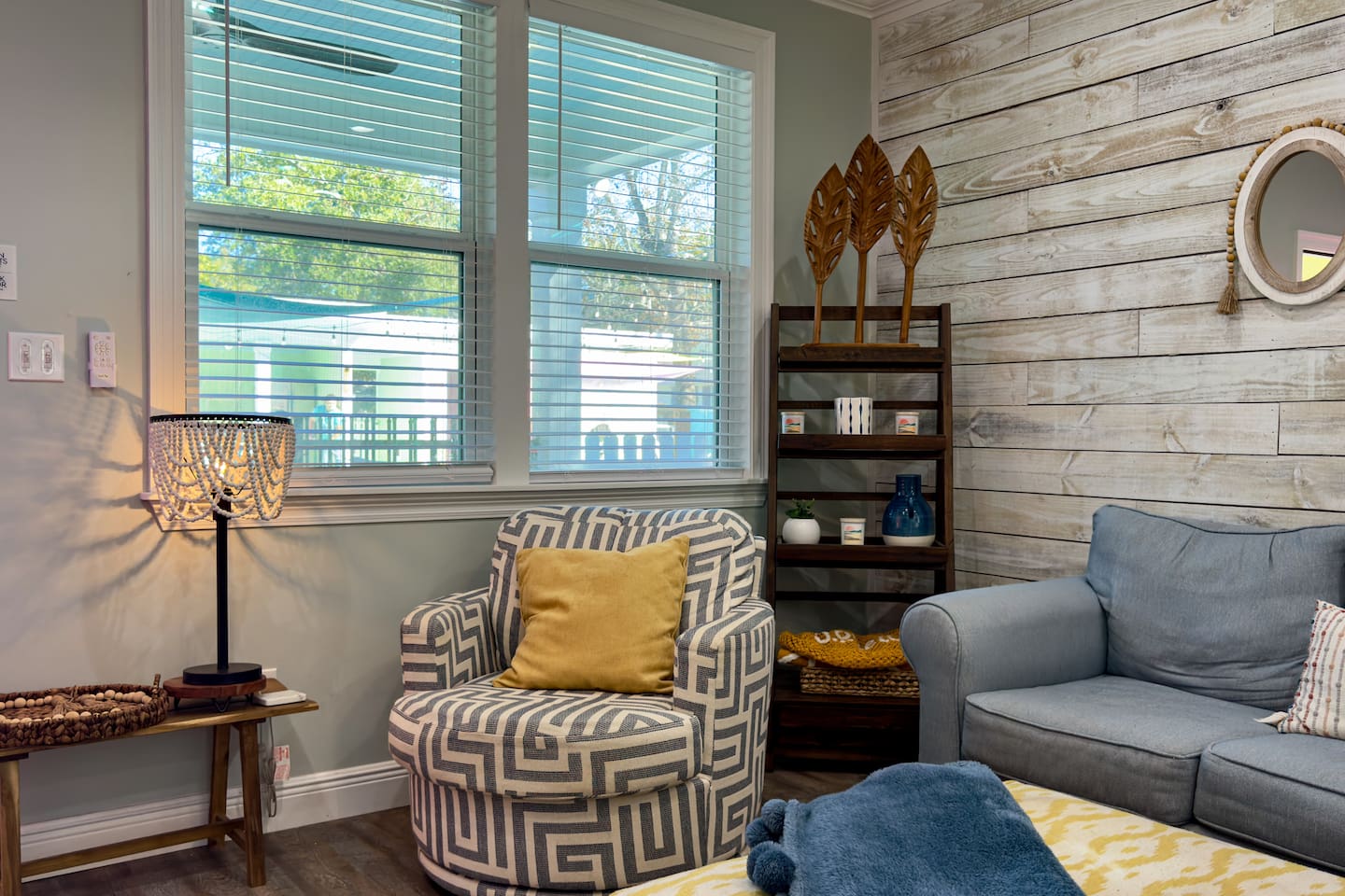 Cozy sitting nook with stylish accent chairs, natural light, and warm coastal decor.