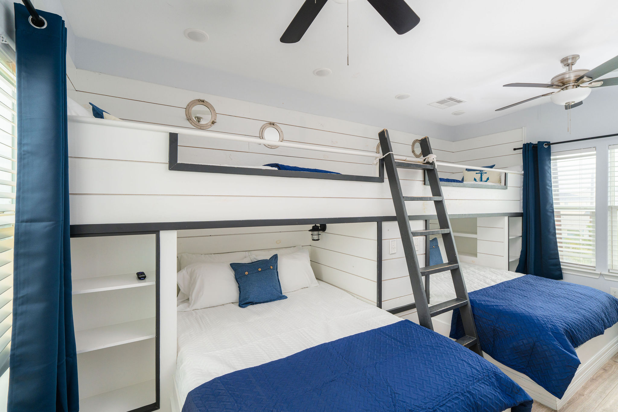 Bunk Room upstairs — two twin-over-queen built-ins, 55" TV, nautical portholes. Sleeps 6 kids (or kids-at-heart).