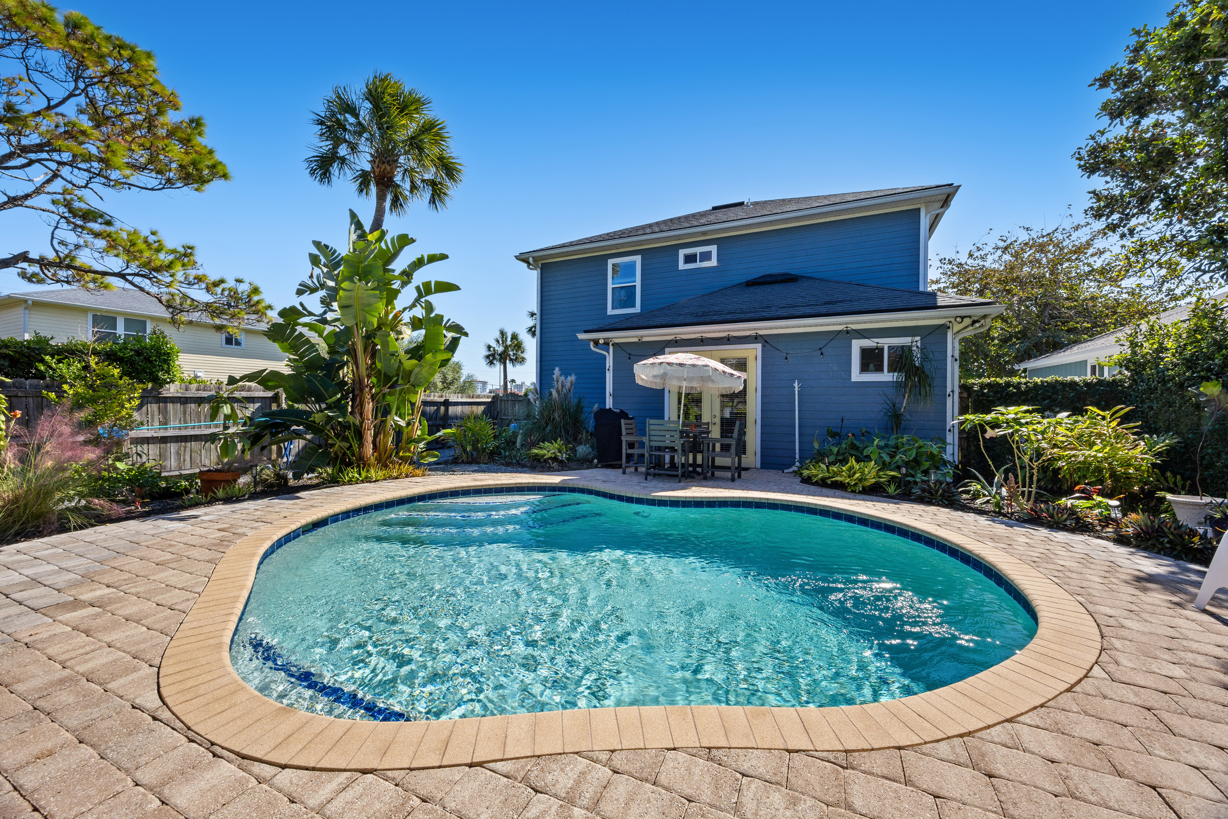 Sunny Backyard Pool Oasis
A sparkling kidney‑shaped pool surrounded by lush landscaping and a spacious patio. Comfortable seating and a shaded dining area create an inviting space for lounging and entertaining.