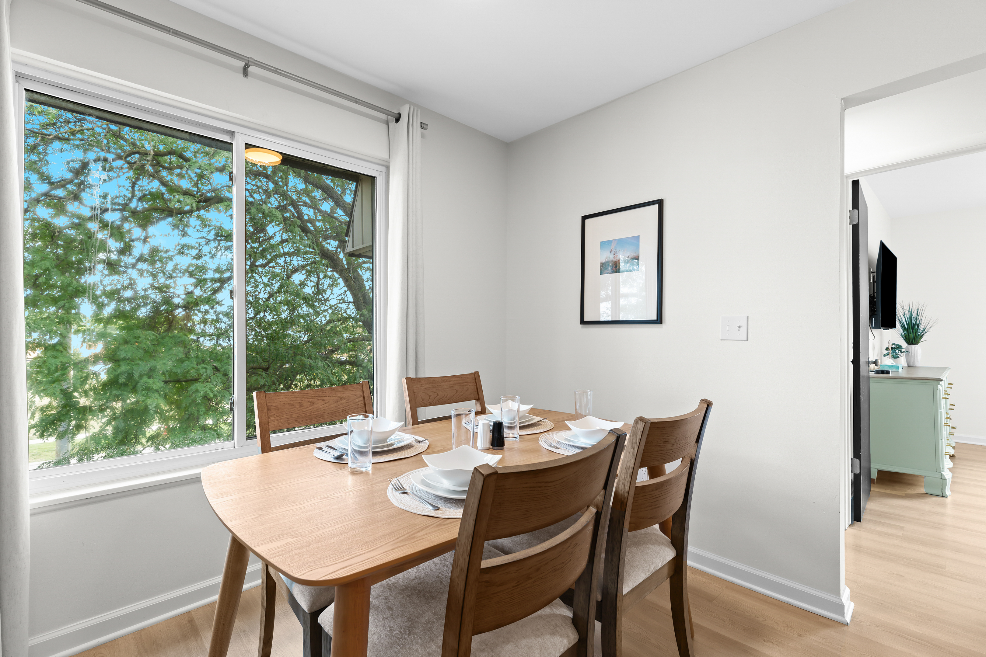 Bright dining nook with seating for four and a lovely outside view.