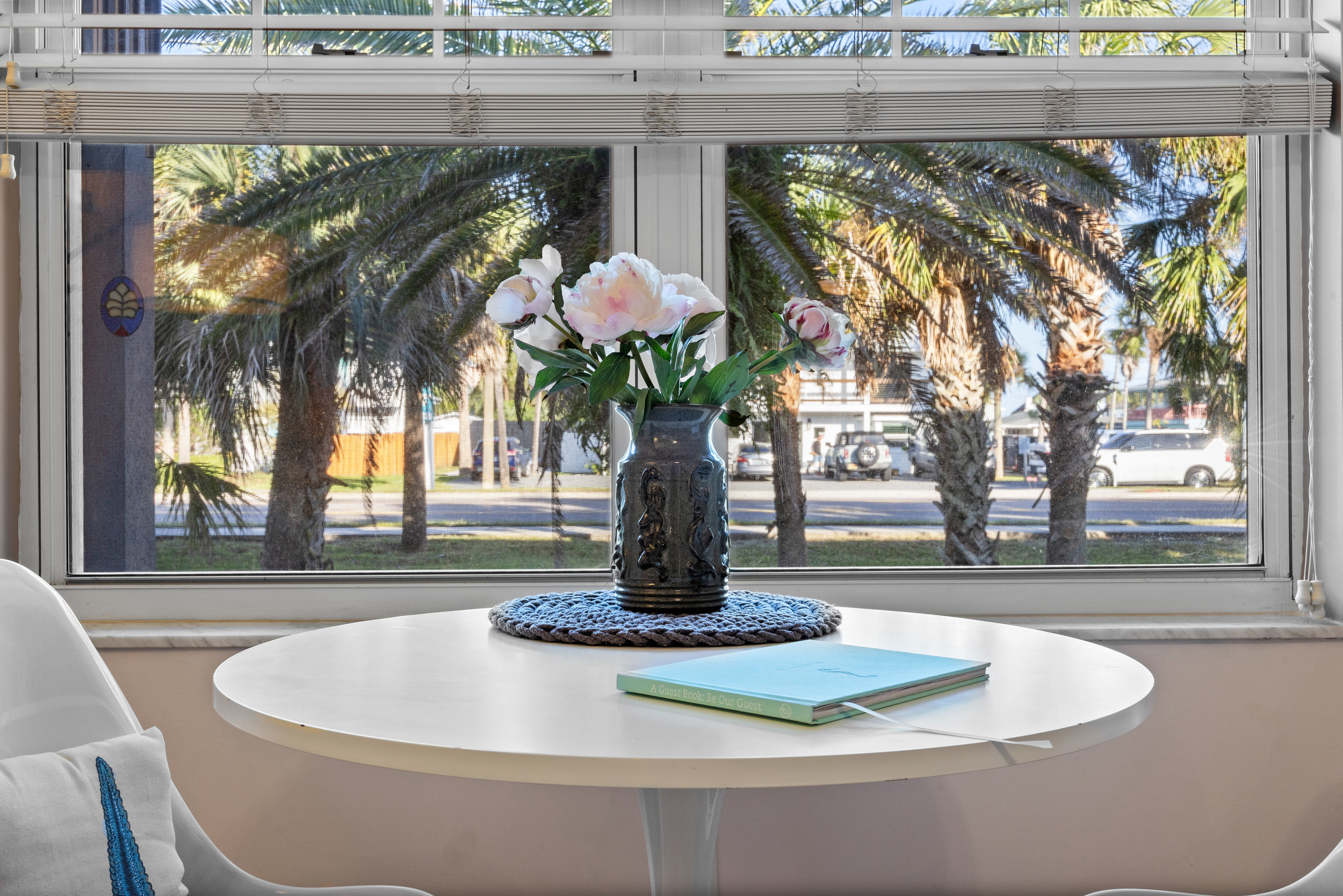 Bright and cozy coffee corner with a breezy view of outside palms.