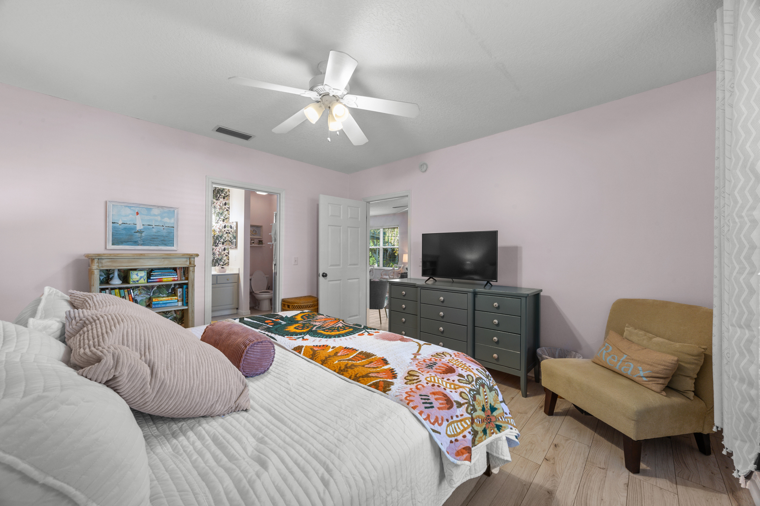 Coastal-inspired bedroom featuring bright bedding and thoughtful decorative touches.