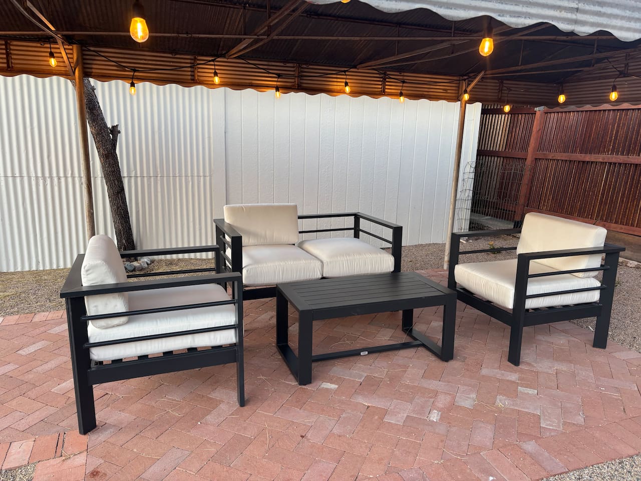 Outdoor sitting area under shade structure with outdoor lights