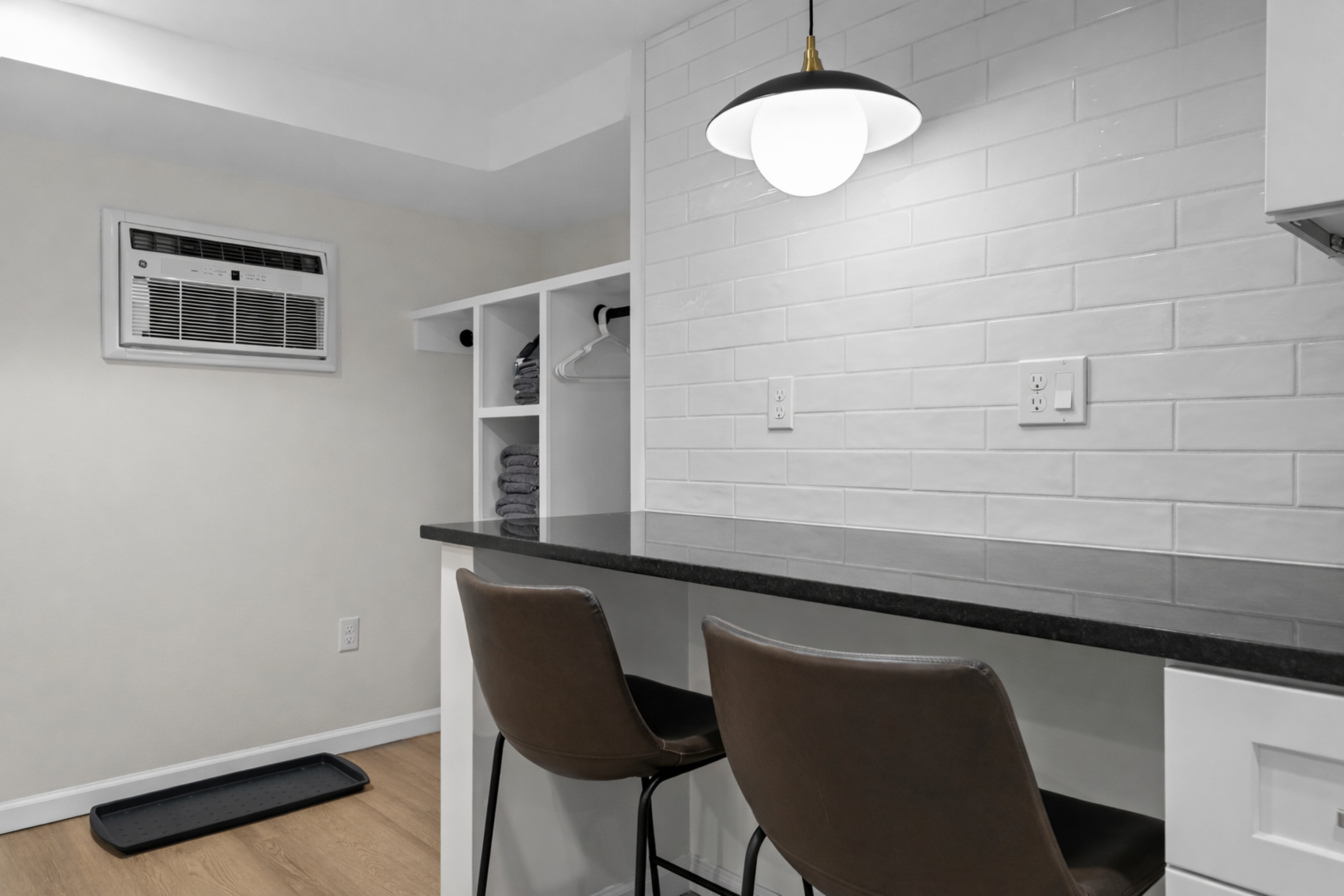 Clean, modern bar seating area with sleek countertops, stylish lighting, and open storage—perfect for casual meals, coffee breaks, or working comfortably.