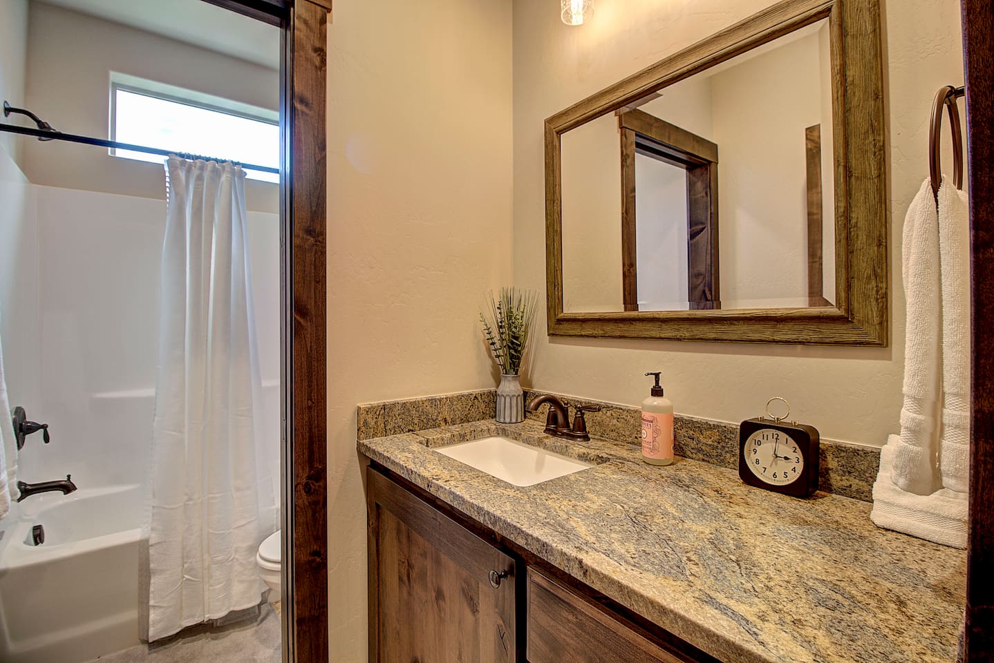 Full shower-tub combo with fresh towels and natural light for a comfortable, refreshing start to your day.