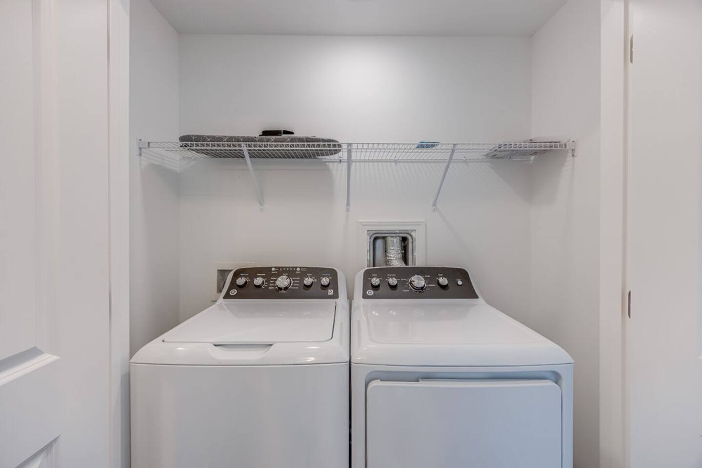 Spacious closet equipped with a washer and dryer, along with an iron and ironing board for added convenience during your stay.