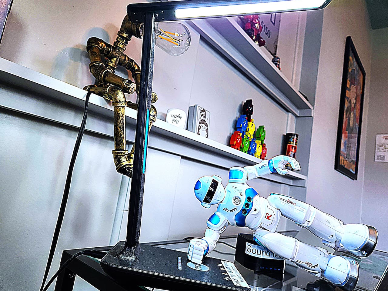 Howie SHOG demonstrates cell charging station and light at desk. 