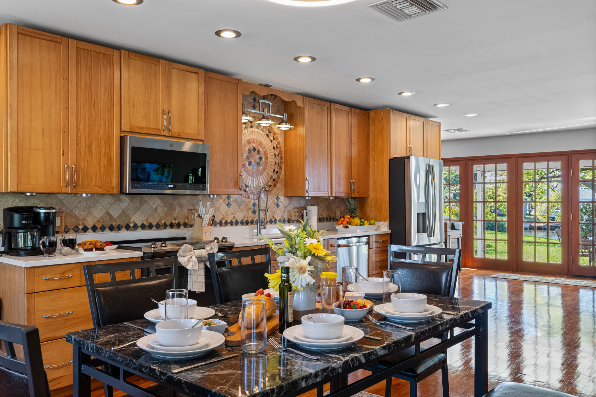 This kitchen showcases beautiful natural wood cabinetry paired with modern stainless steel appliances, offering both charm and functionality.