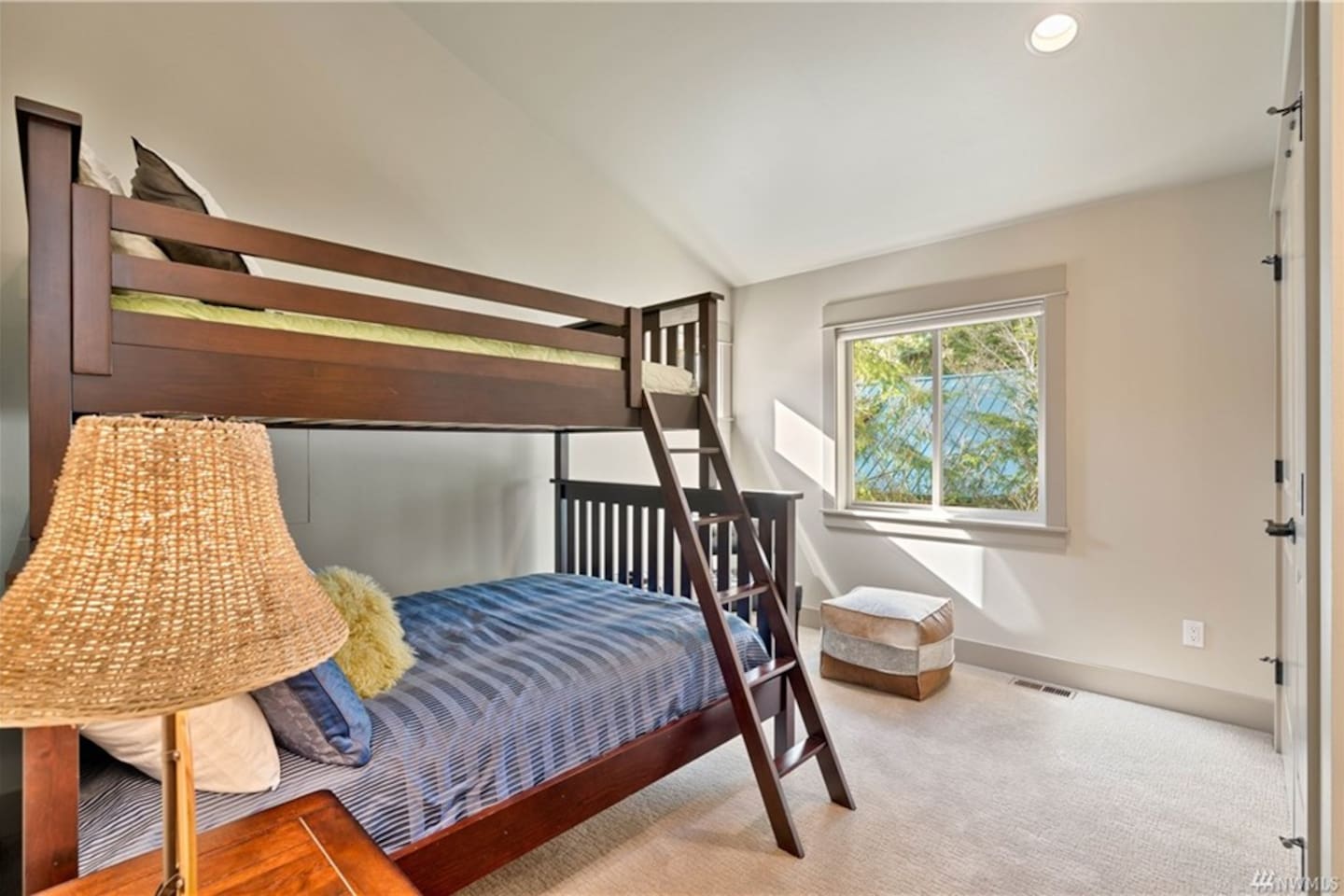 This bunk room features a full-over-twin bed, a large double closet, and drawers for personal belongings. It opens to a Jack and Jill bathroom with a sliding door for privacy.