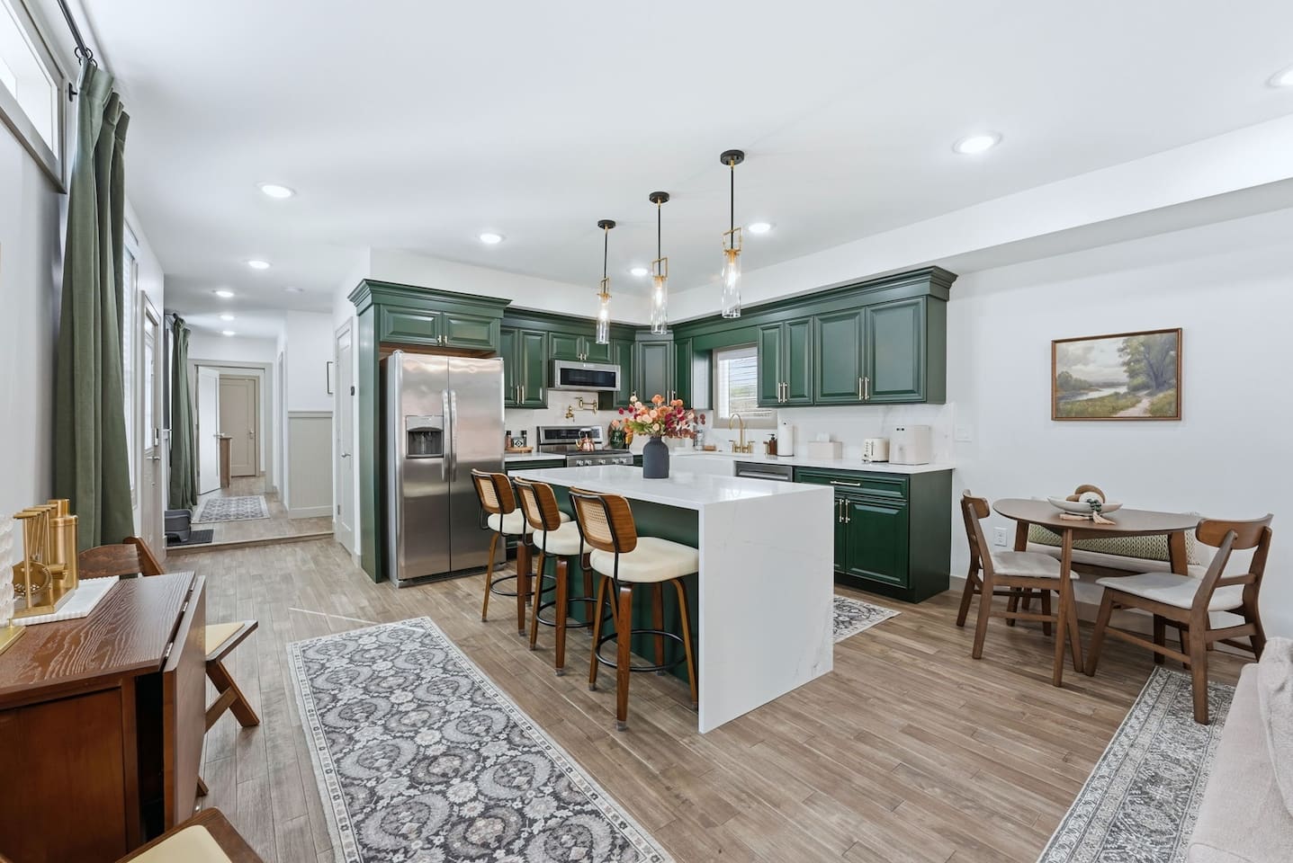 Bright open-concept kitchen and dining area featuring a cozy round dining table for four, perfectly set beside the modern kitchen—ideal for shared meals, family gatherings, and easy entertaining.