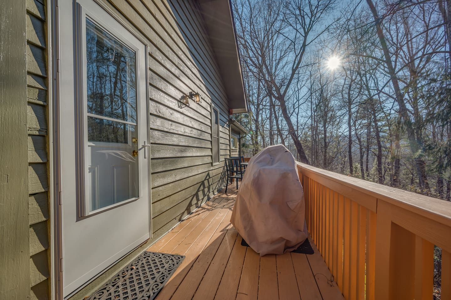 Back deck of home with outdoor seating with bbq pit