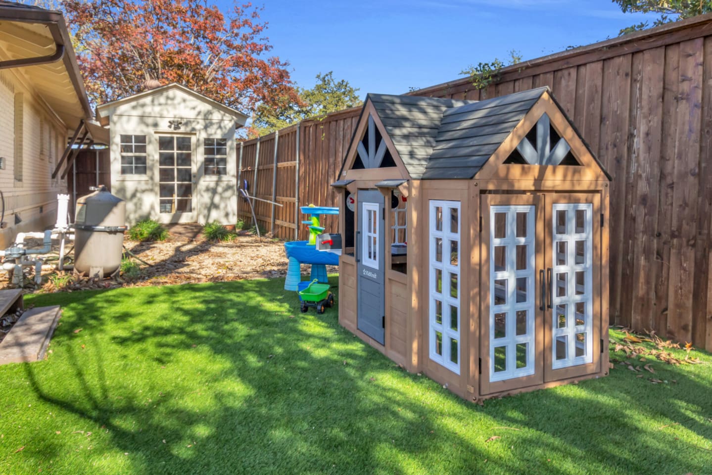 A bright, open backyard play zone with artificial turf for soft landings and endless fun—ideal for families looking for a kid-friendly stay.