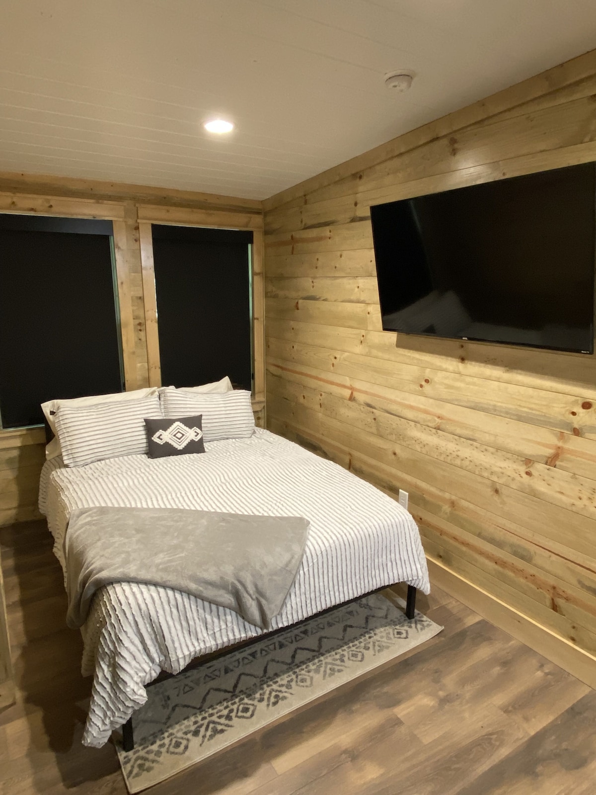 Upstairs: queen bed, smart TV, box fan, privacy shades, and child safety gate