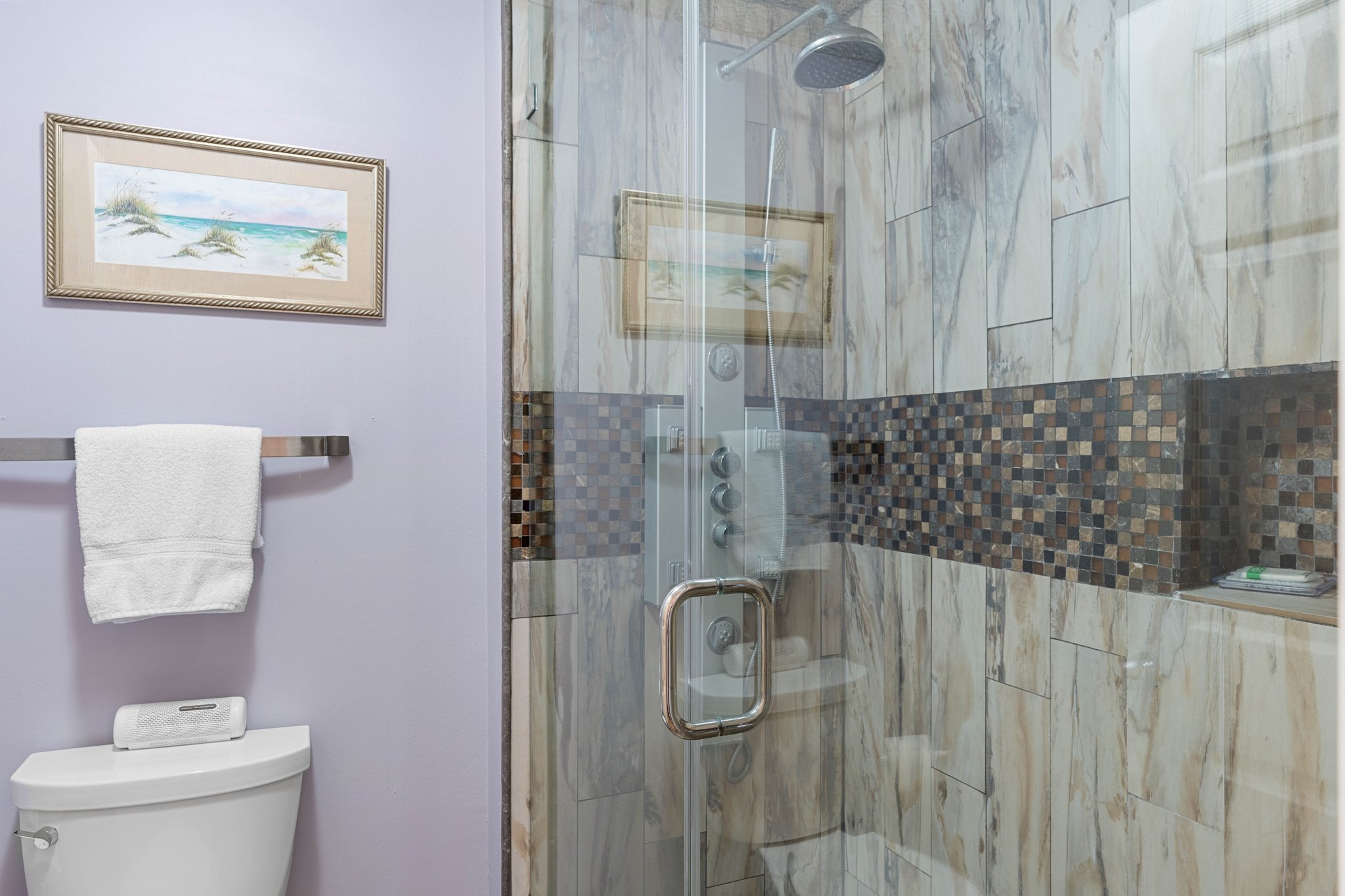 Clean bathroom setup w/ tub & shower combo, bright lighting & simple finishes.