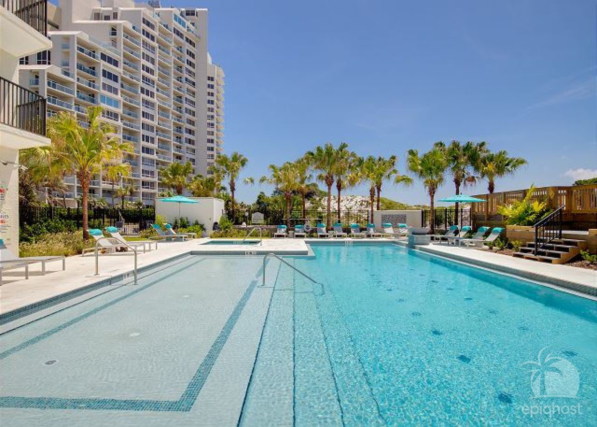 Pool deck with lounge seating and palm trees