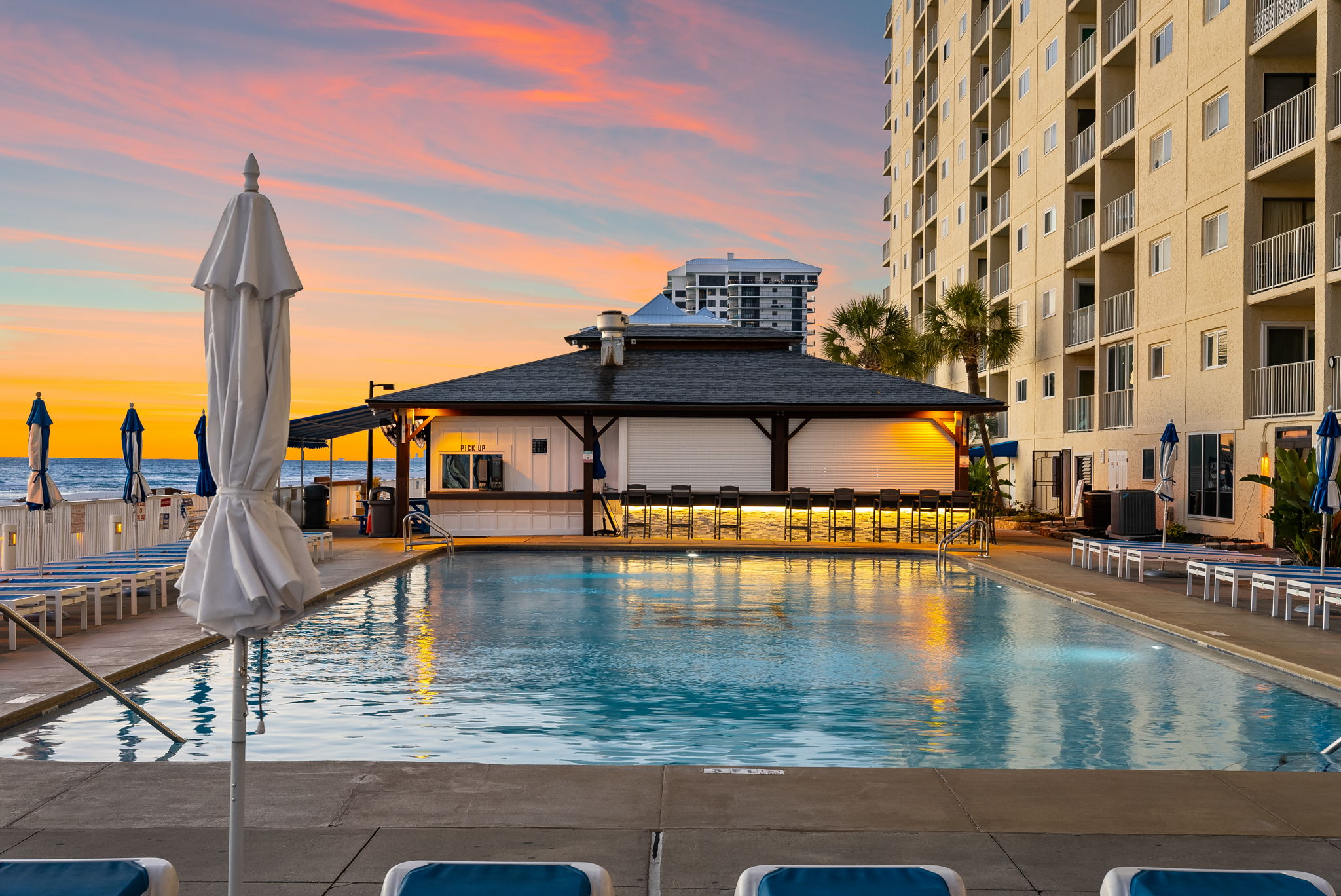 The View across one of the pools and the sea to the Sand Bar. The Sand bar is open seasonally offering delicious food and drinks, the perfect place to enjoy the best sunsets in America!