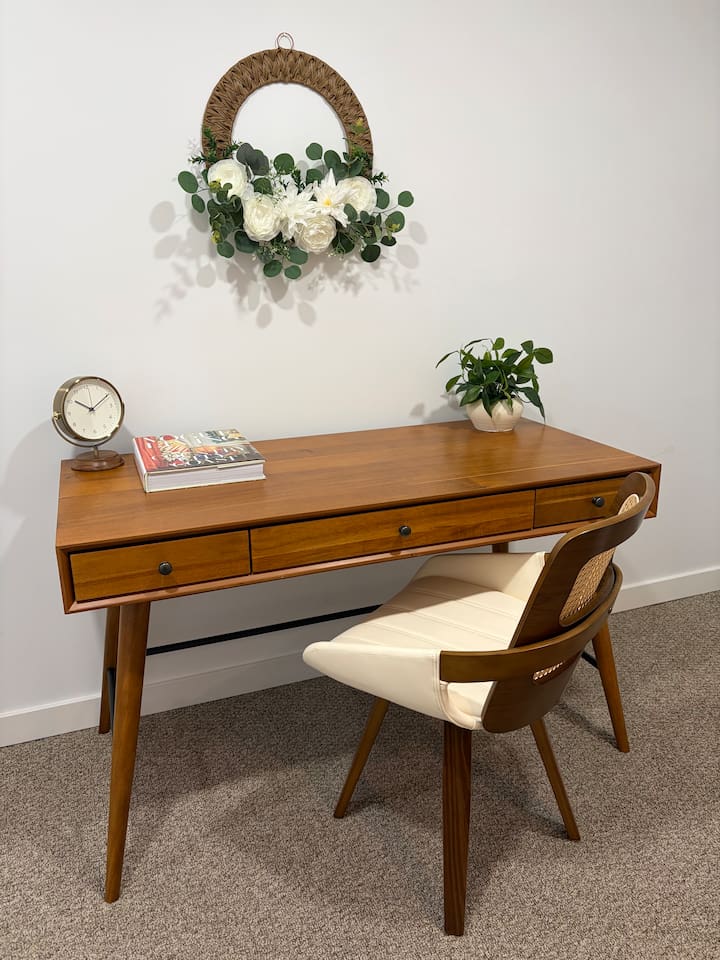Dedicated workspace with a spacious wooden desk, a comfortable chair, and a quiet, calming setup for remote work.