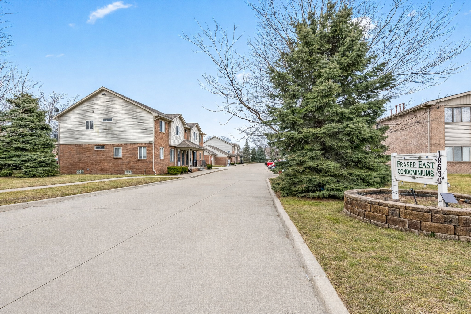 Quiet, tree-lined condo community with well-kept buildings and easy access to parking and nearby main roads.