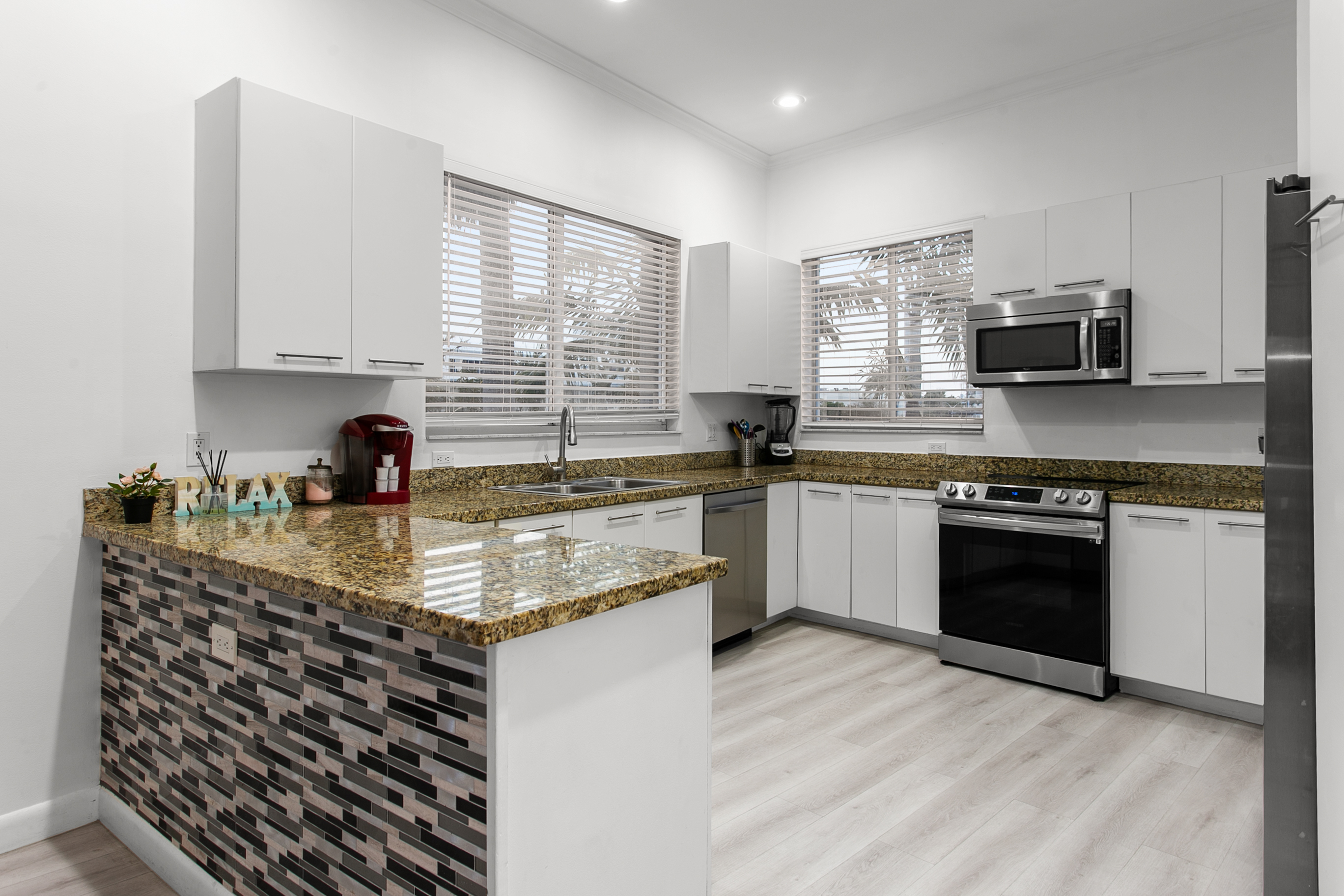 Well-equipped kitchen with breakfast counter and natural light from windows