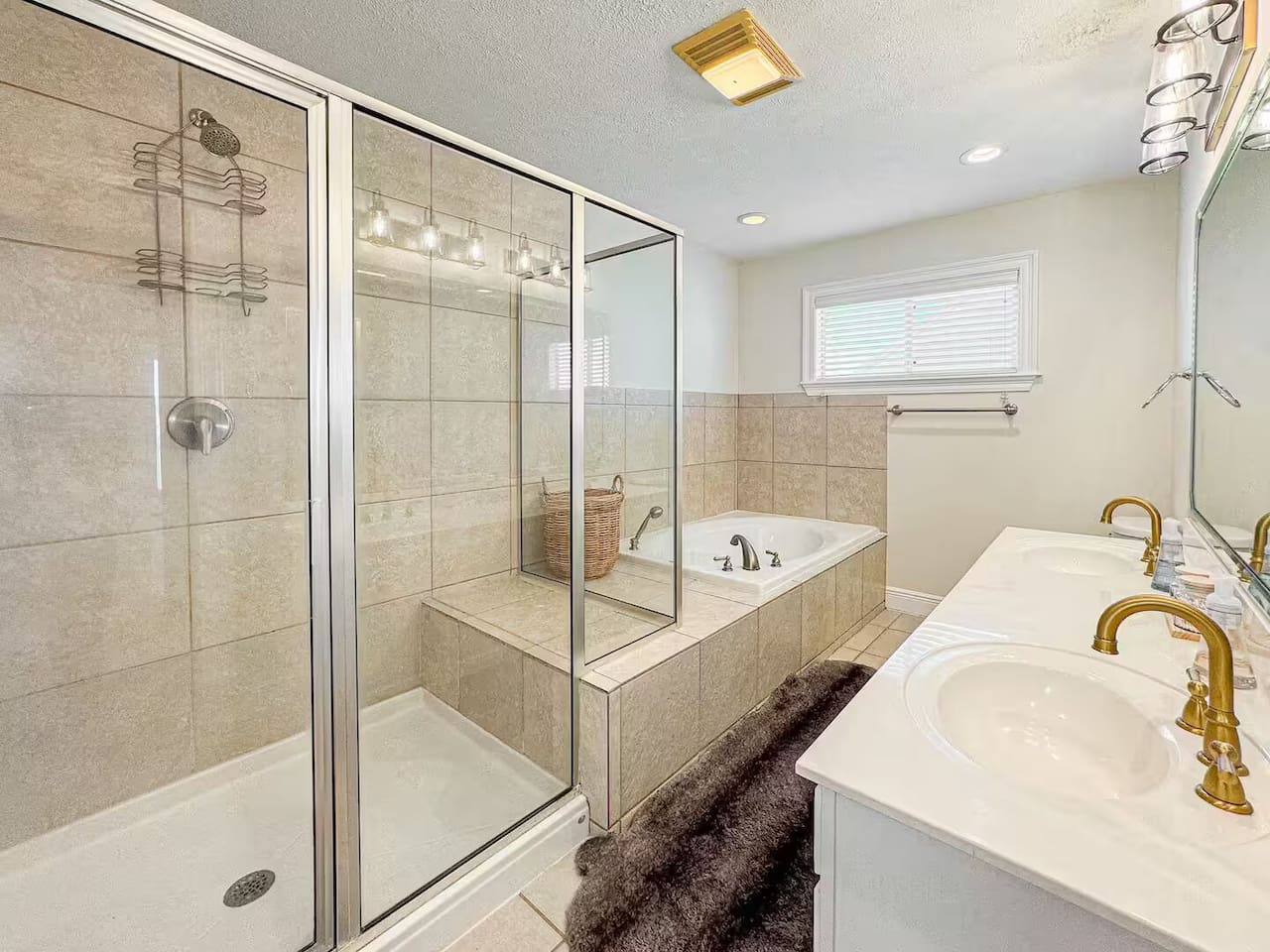 Spacious bathroom with a glass-enclosed shower, soaking tub, and double vanity. Bright, clean design with modern fixtures for a spa-like experience.