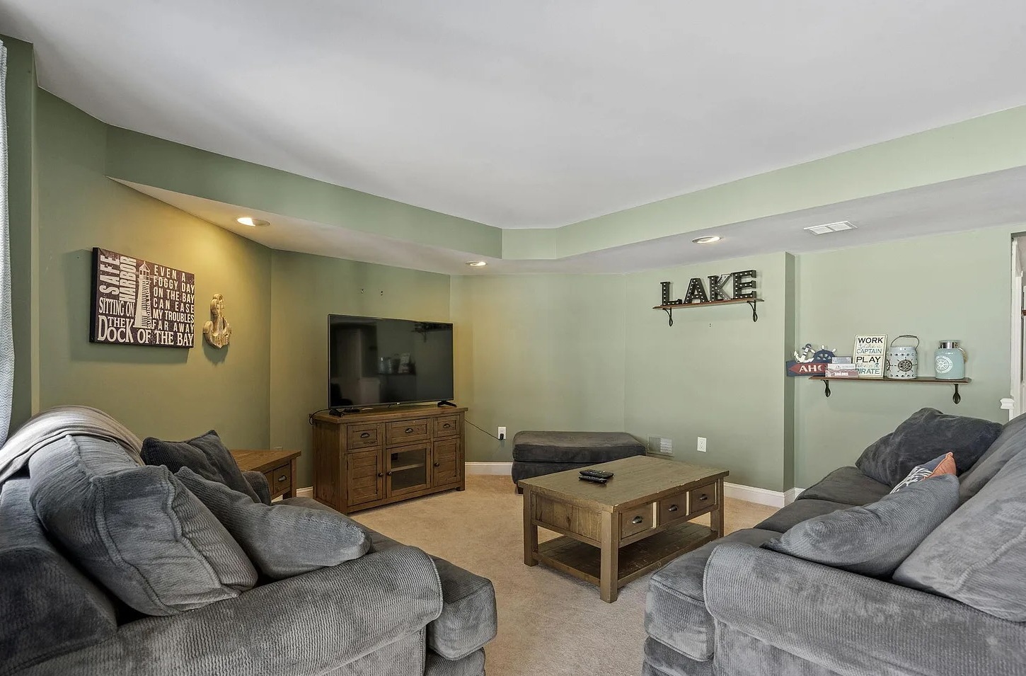 A cozy lower-level hangout featuring oversized seating and a large TV - ideal for movie nights and late-night gatherings.