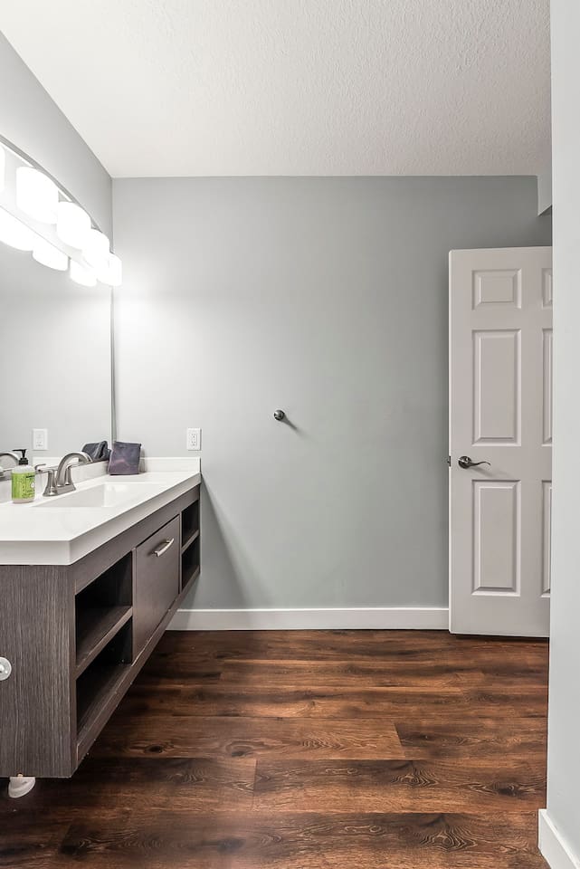 Spacious vanity area with contemporary lighting, large mirror, and plenty of room for daily routines.