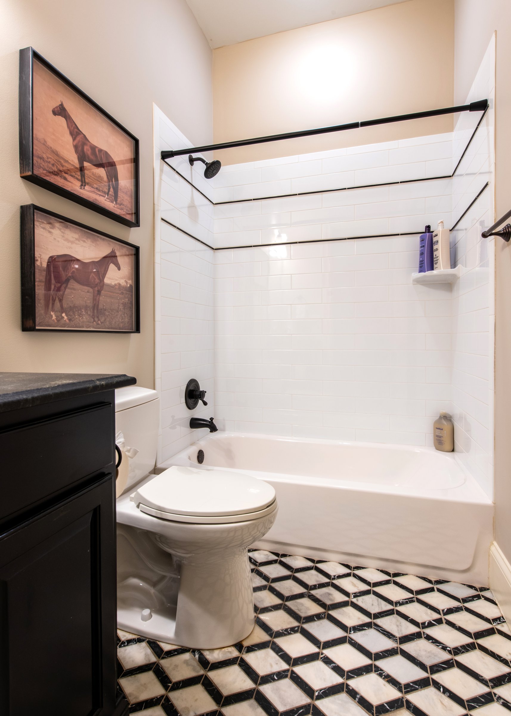 Classic black-and-white tile floor and a tub/shower combo.