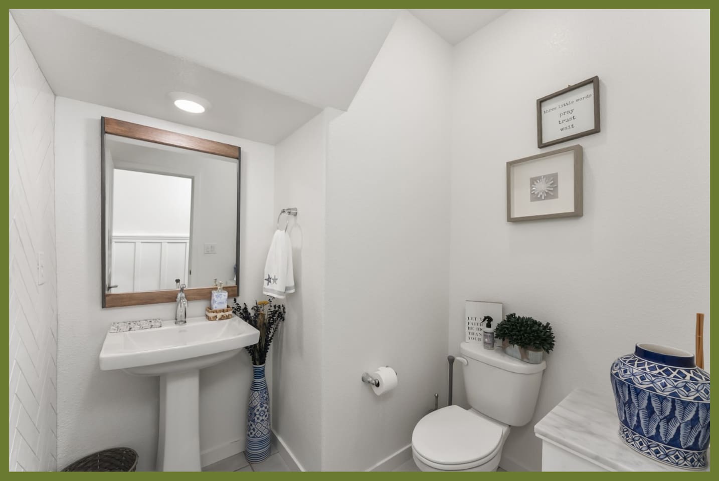 Bathroom with pedestal sink, mirror, fresh towel, and simple guest-ready essentials.
