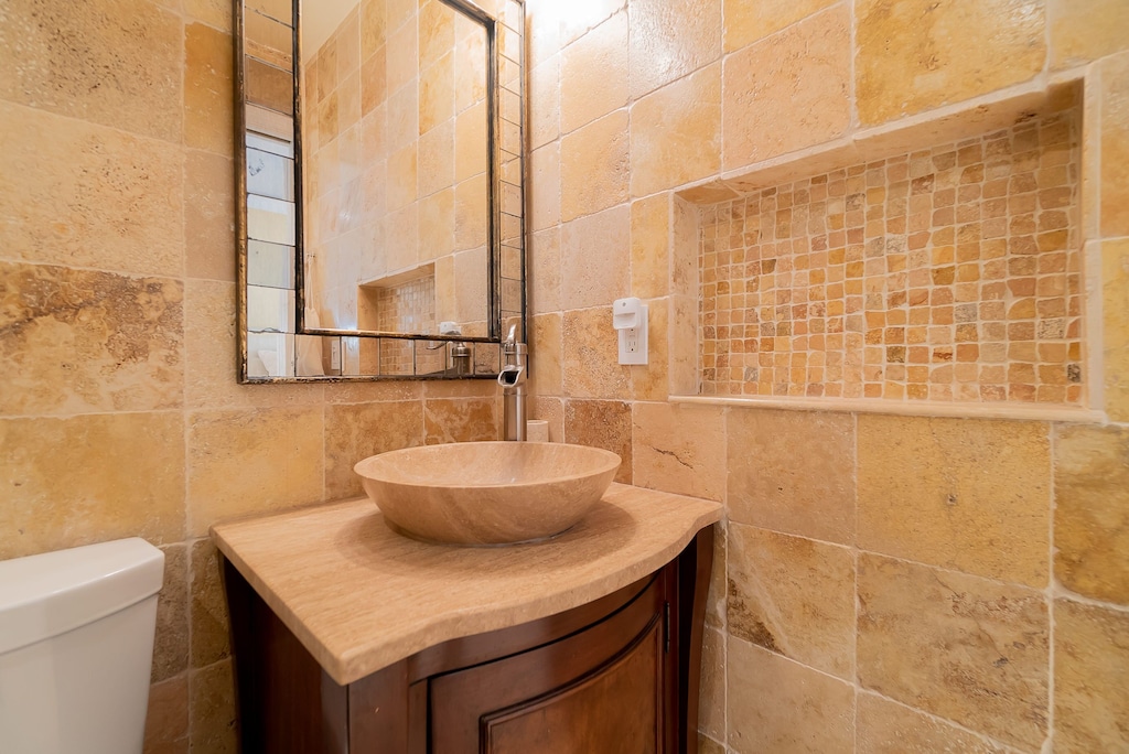 Stone tile renovated bath w/cut out for toiletries.