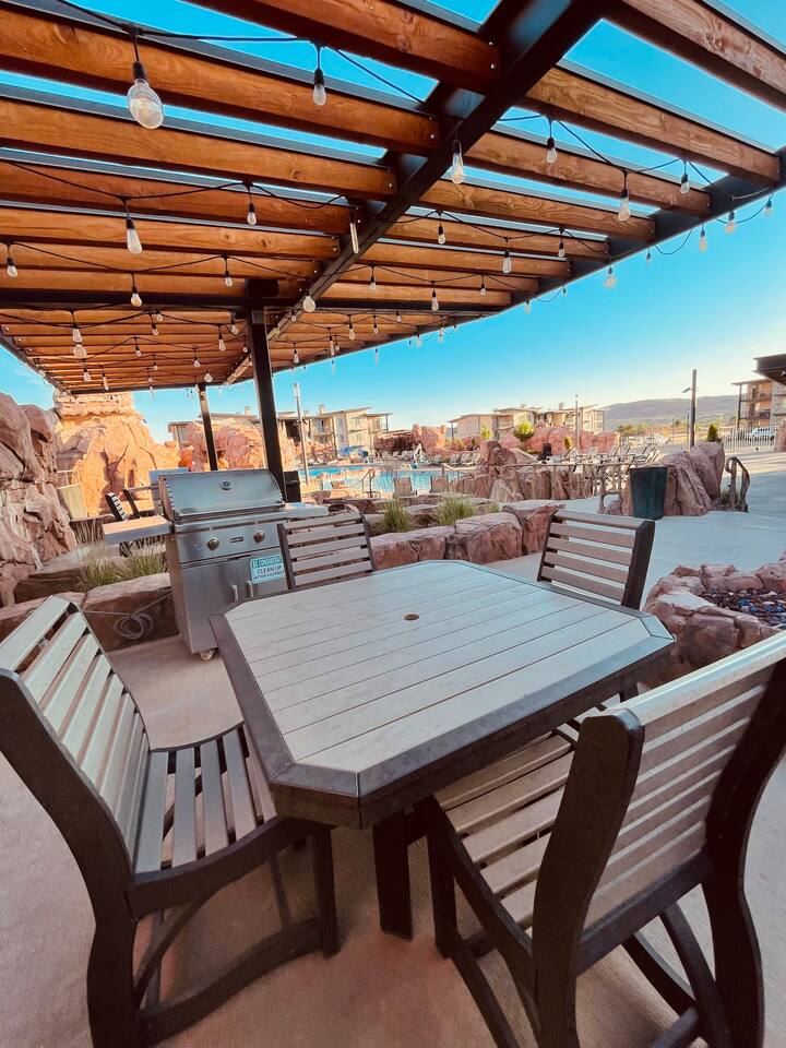 Tables and barbeque grills underneath lighted pergola