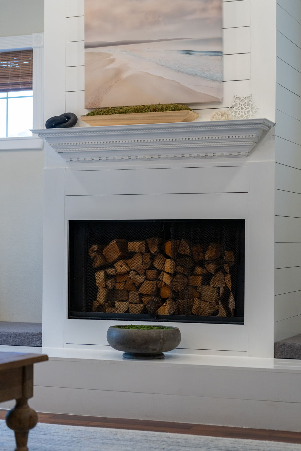 The fireplace’s built-in storage for firewood adds both practicality and a rustic decorative element.