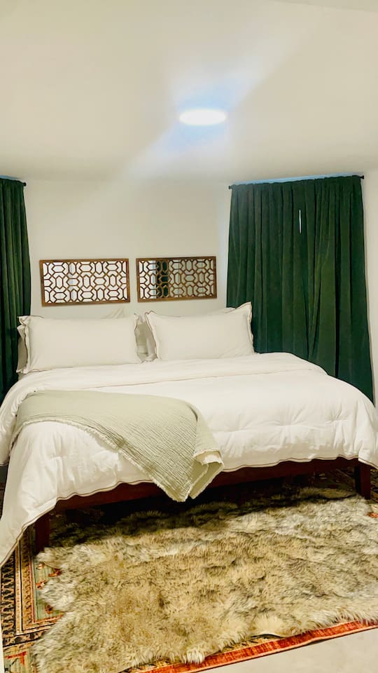 Stylish bedroom with comfortable bedding and cozy decor.