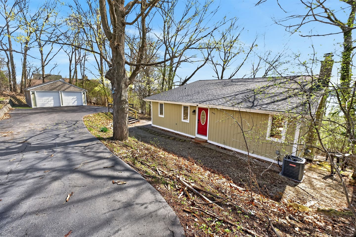 Welcome to your peaceful retreat 
A private, tree-lined driveway leads you to the charming entrance with a bold red door, offering both curb appeal and privacy. Enjoy ample parking with a spacious detached garage and additional spots—perfect for mu