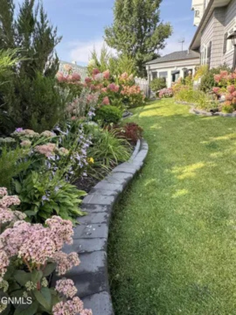 Beautiful flowers, fresh greenery, and a manicured yard make the outdoor space easy to enjoy.