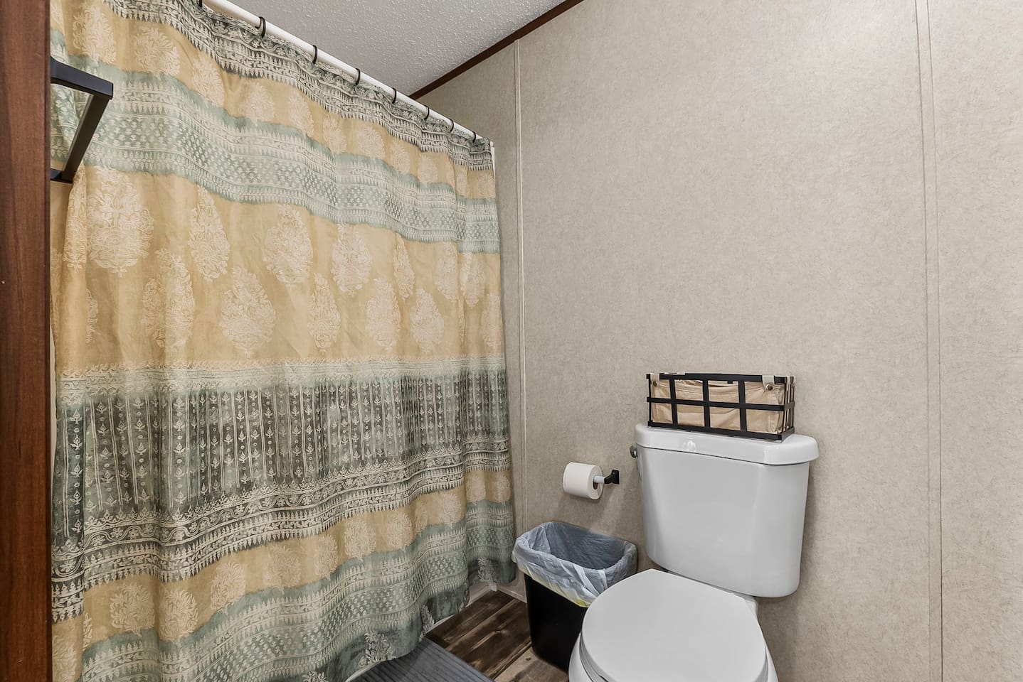 Full bathroom setup with shower and tub combination, fresh shower curtain, and all the essentials for a comfortable stay.