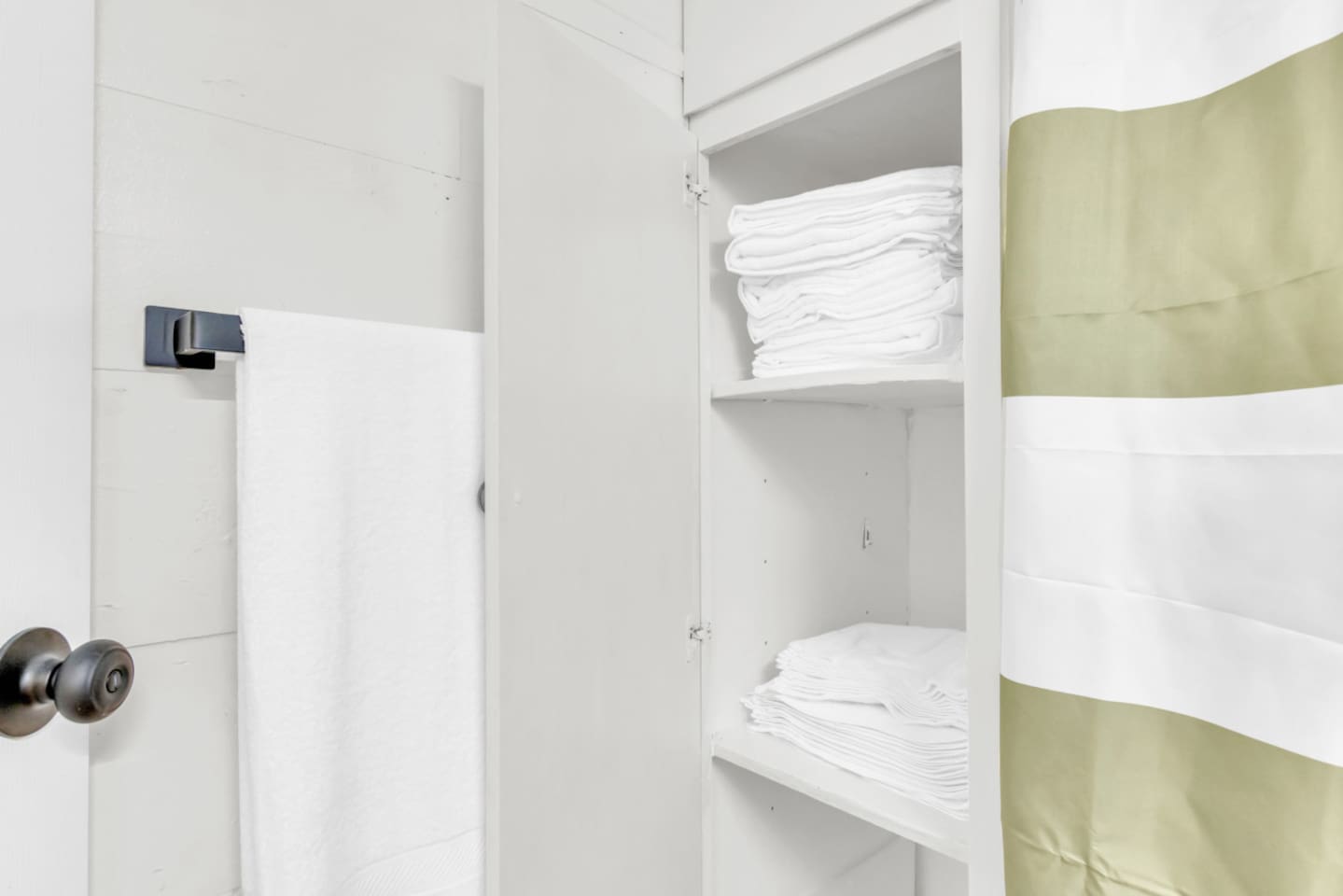 Bathroom with ample storage space and towels .