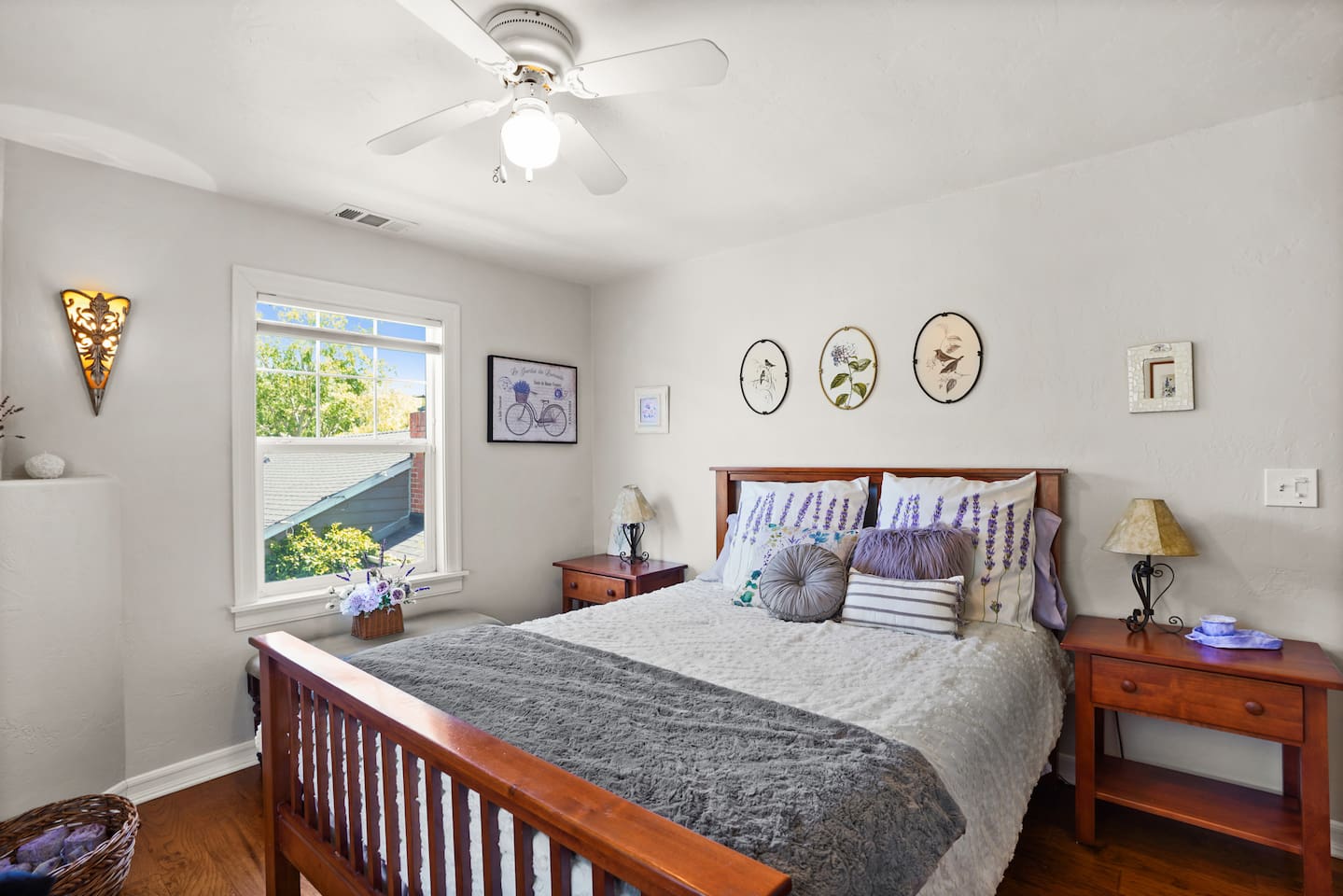 Bright and airy guest bedroom with a basket for storing extra bed pillows during your stay.