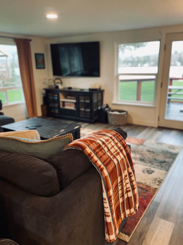 From the kitchen, the living area unfolds beyond the couch with the TV, perfect for game days or movie nights.