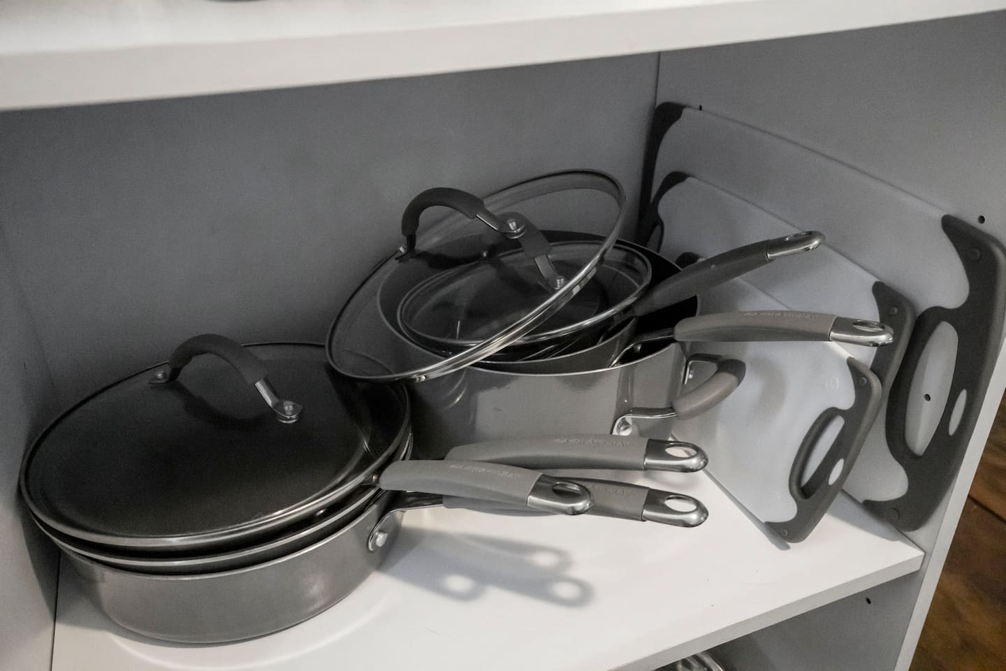 Close-up view of pots, pans, and cutting boards, offering all the kitchen essentials for meal preparation."