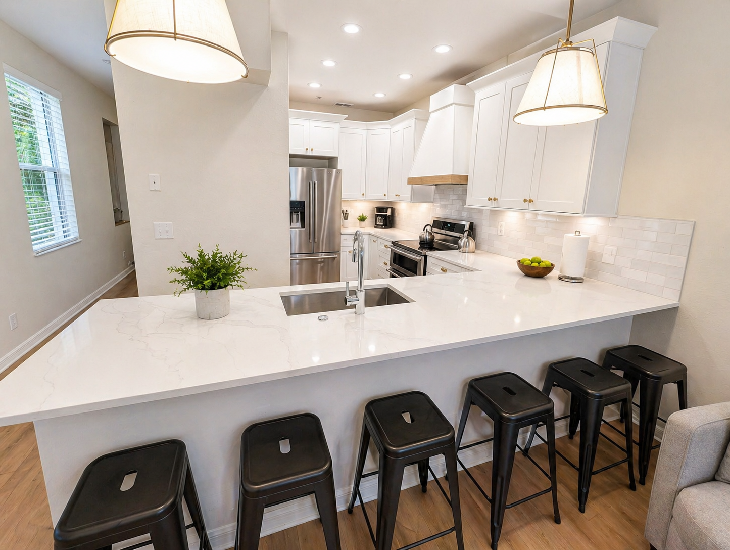 Modern, fully equipped kitchen with sleek white cabinetry, stainless steel appliances, and a spacious island with bar seating—perfect for cooking, dining, or entertaining. Bright lighting and an open layout make it the heart of the home.