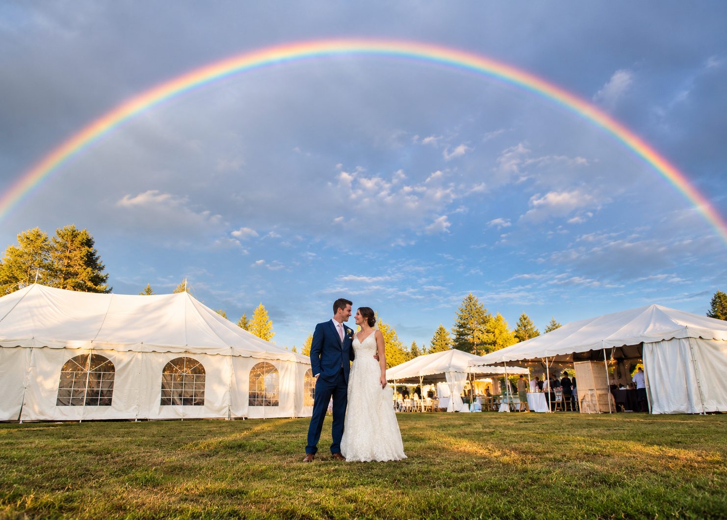 Couple under a rainbow beside the reception tent at Casa Vista