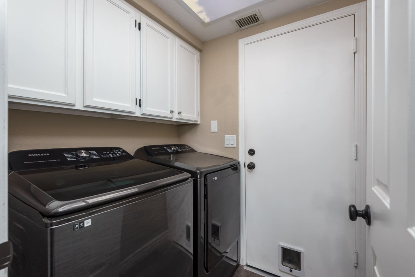 Washer and dryer available inside the home, with cabinet storage for everyday convenience.